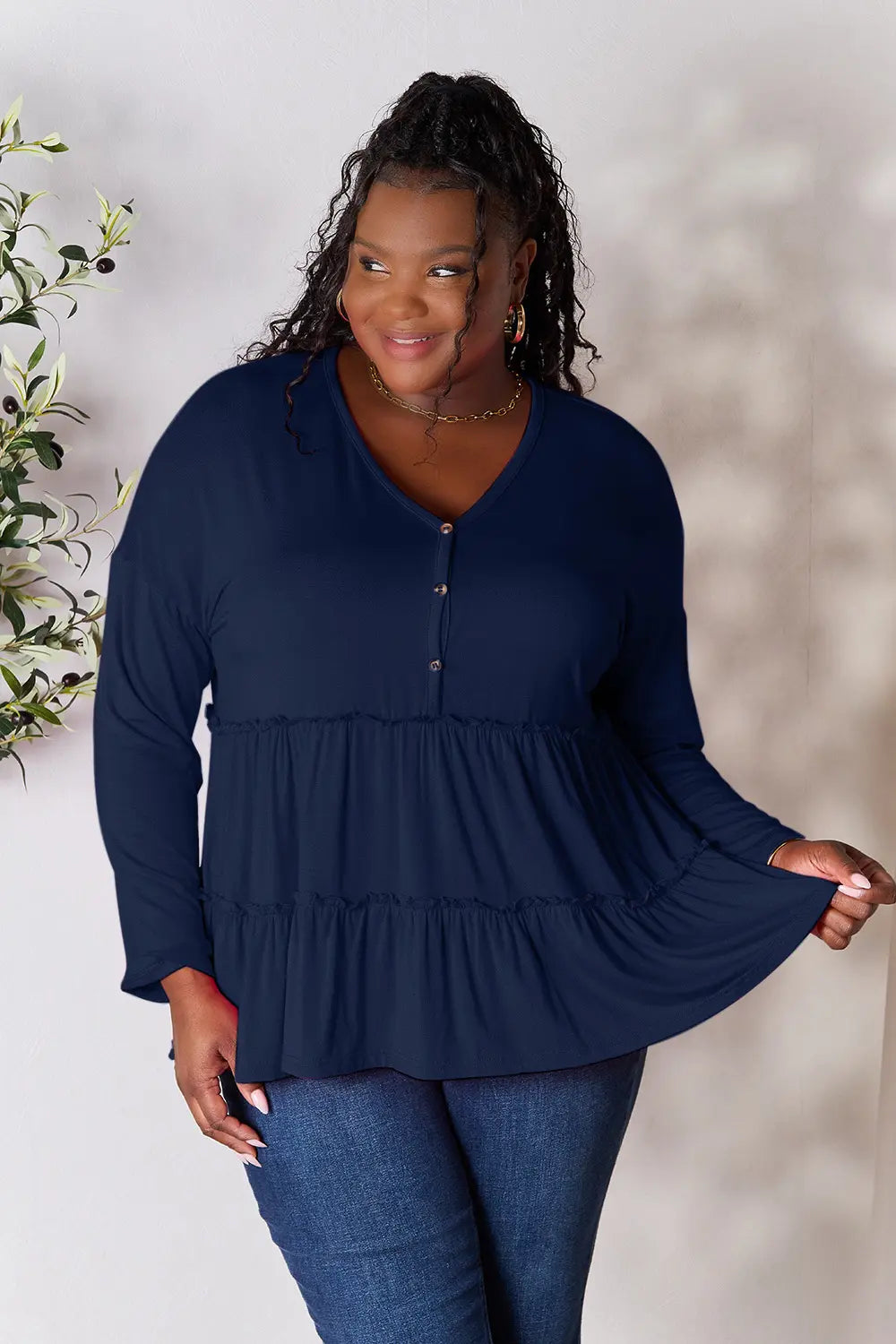 Dark blue long-sleeve blouse with half-button front and tiered ruffle hem