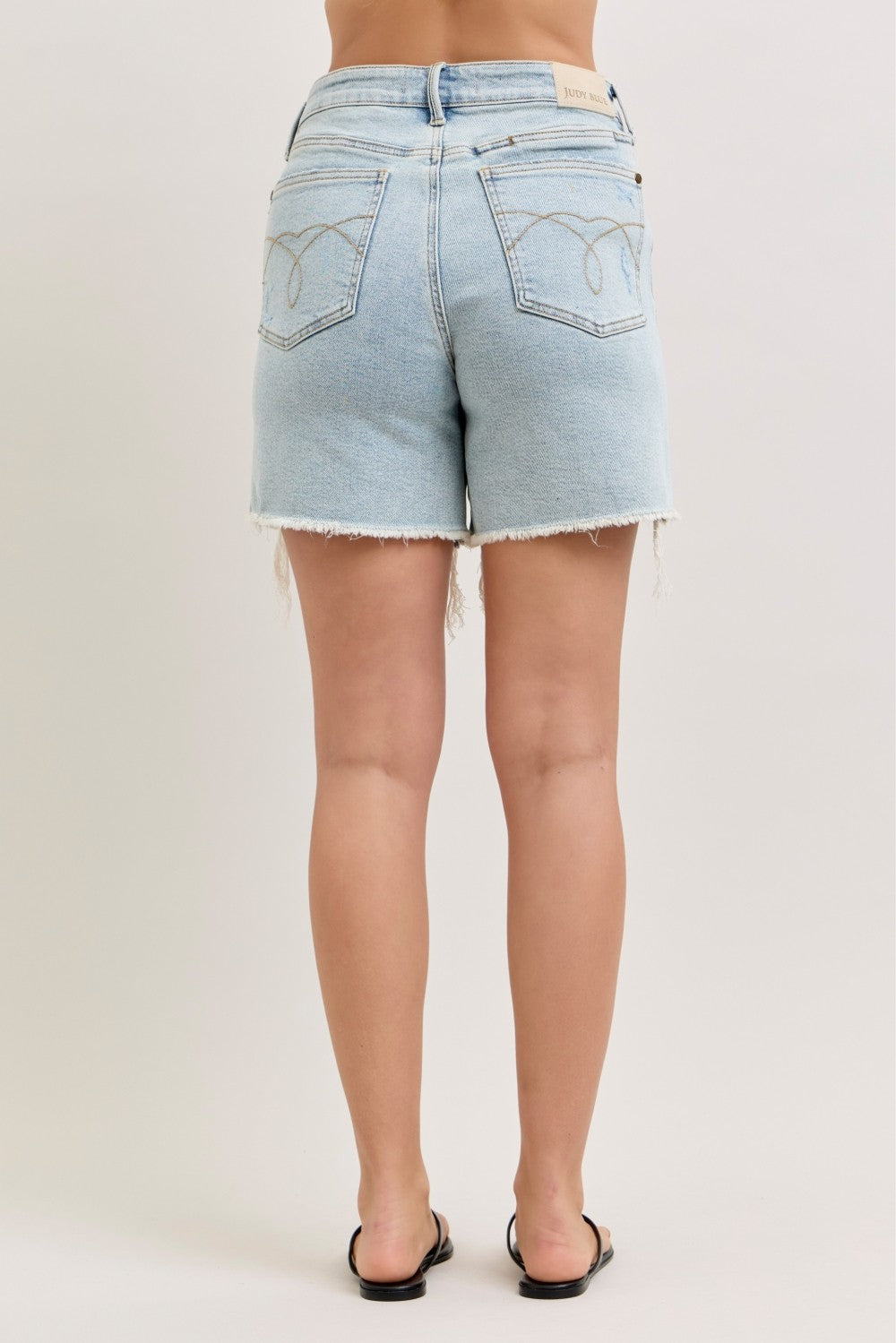 Light wash rigid dad shorts, high-rise back view with two pockets and frayed edges