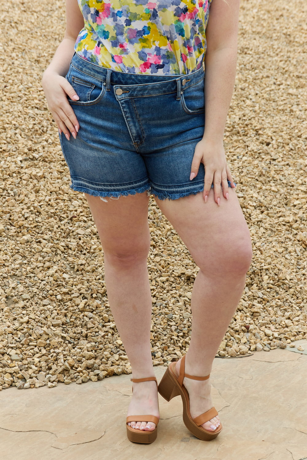 Medium-wash denim shorts with frayed hem, button closure, and 5-pocket styling
