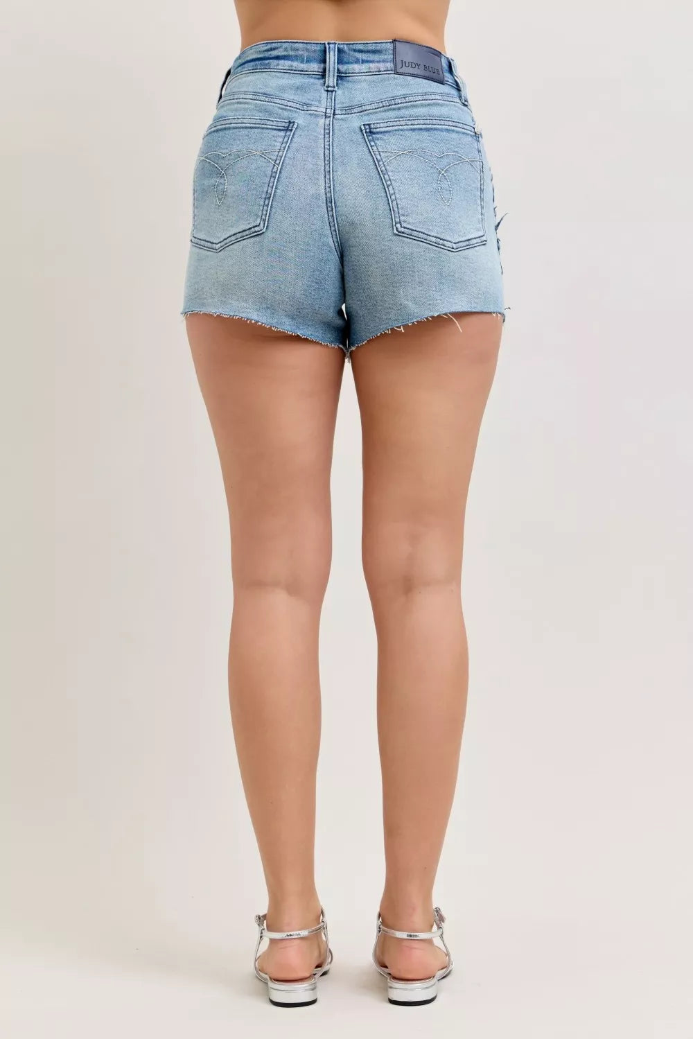 Denim cut-off shorts waistband with belt loops and button-fly, raw hem detail