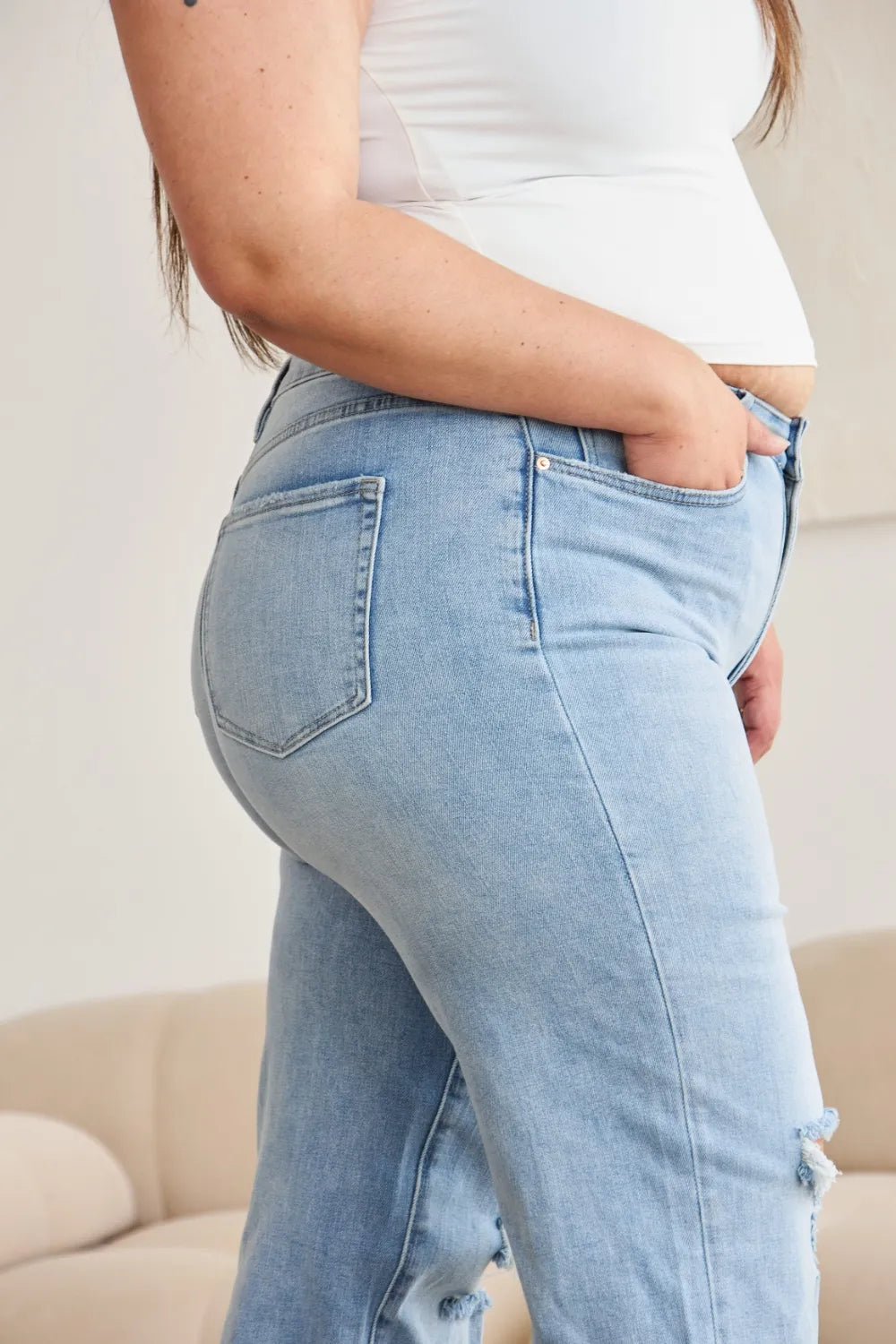 Light wash high-waist jeans with curved back yoke and stitched back pockets
