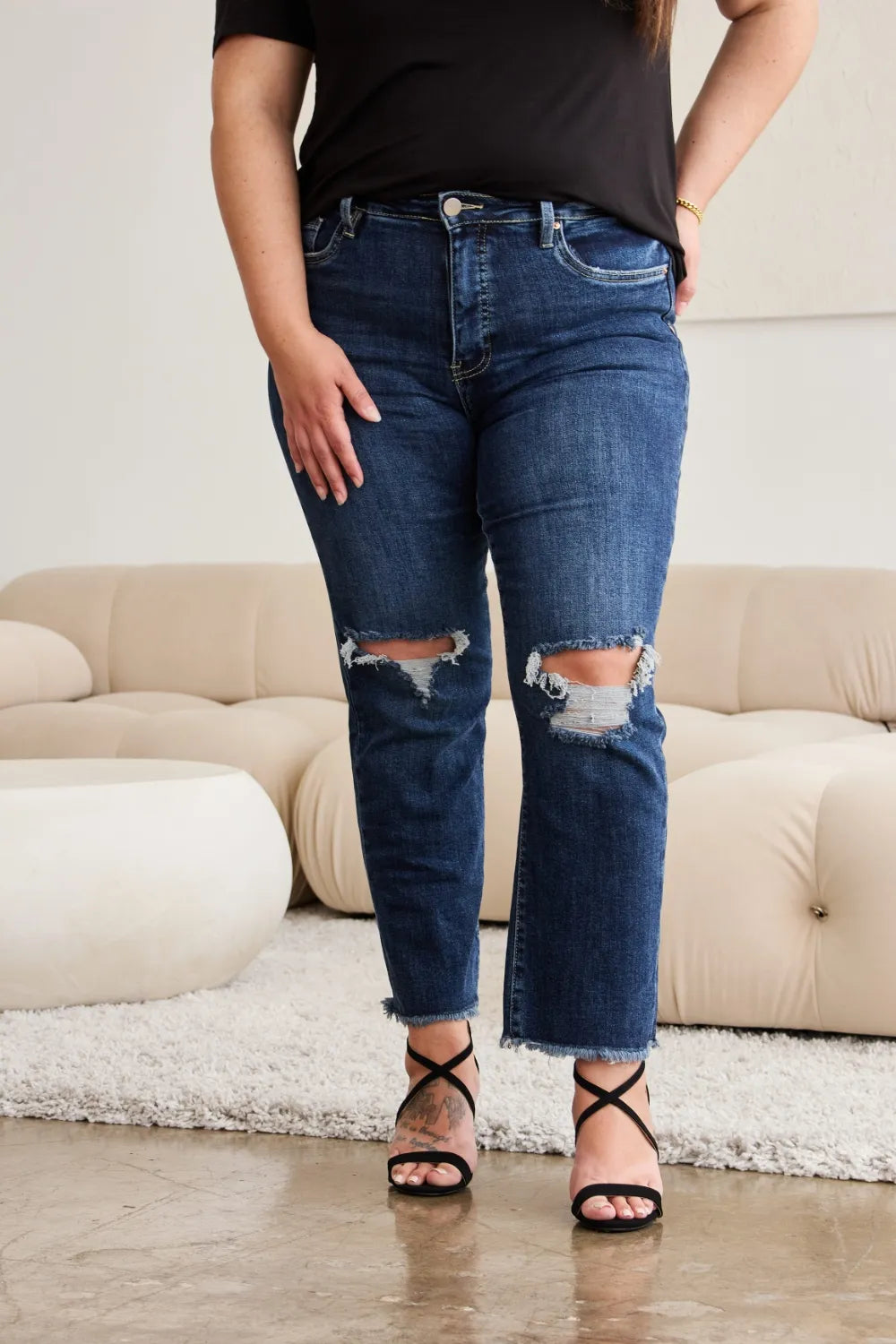 Front close-up: high-waist dark denim with raw hem and distressed knee holes