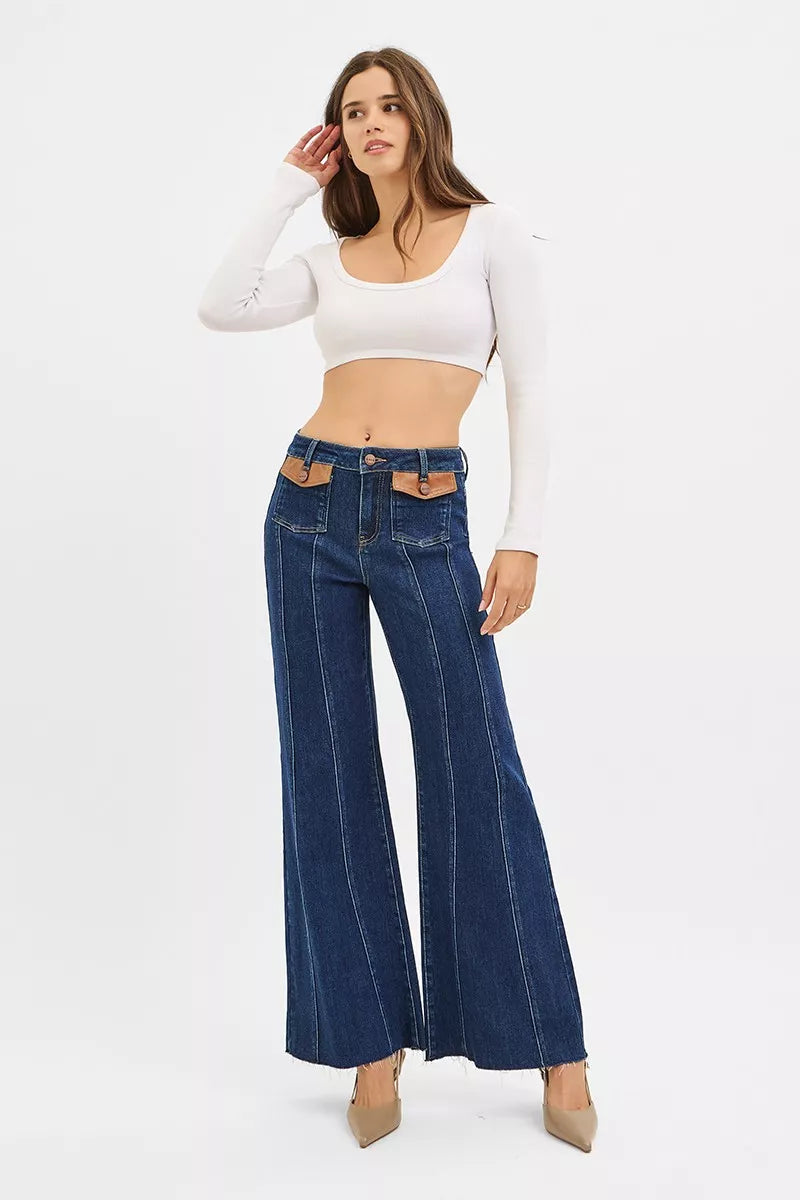 Front view of dark blue high-rise wide flare jeans with leather pocket accents