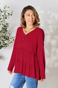 Burgundy long-sleeve blouse with V-neck half-button front and tiered ruffle hem