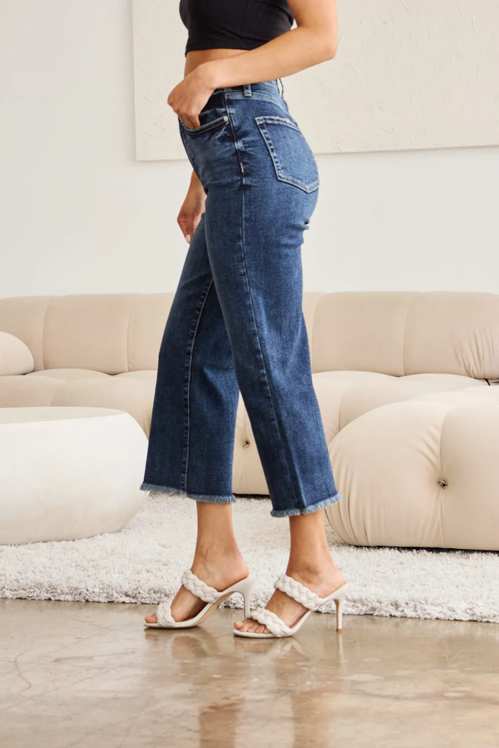 Side view high-waist dark-wash jeans with raw cuff hem and wide leg