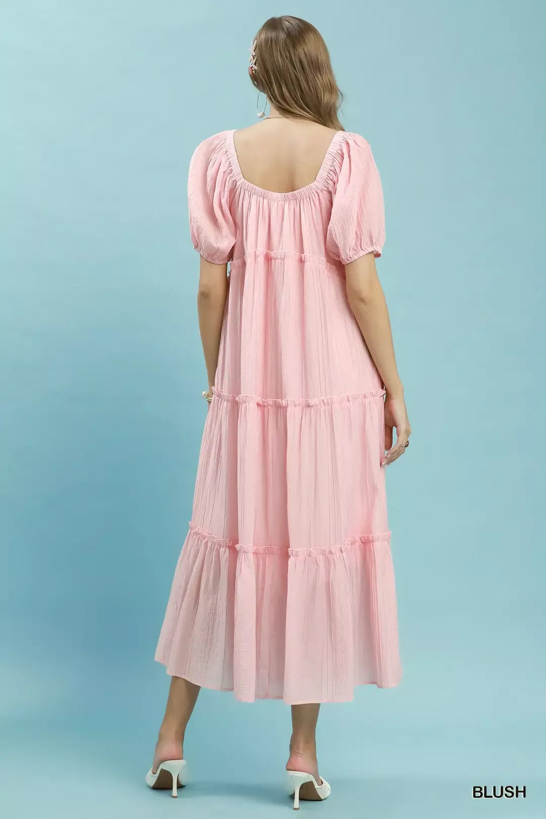 Blush tiered midi dress, back view with gathered yoke and puff sleeves