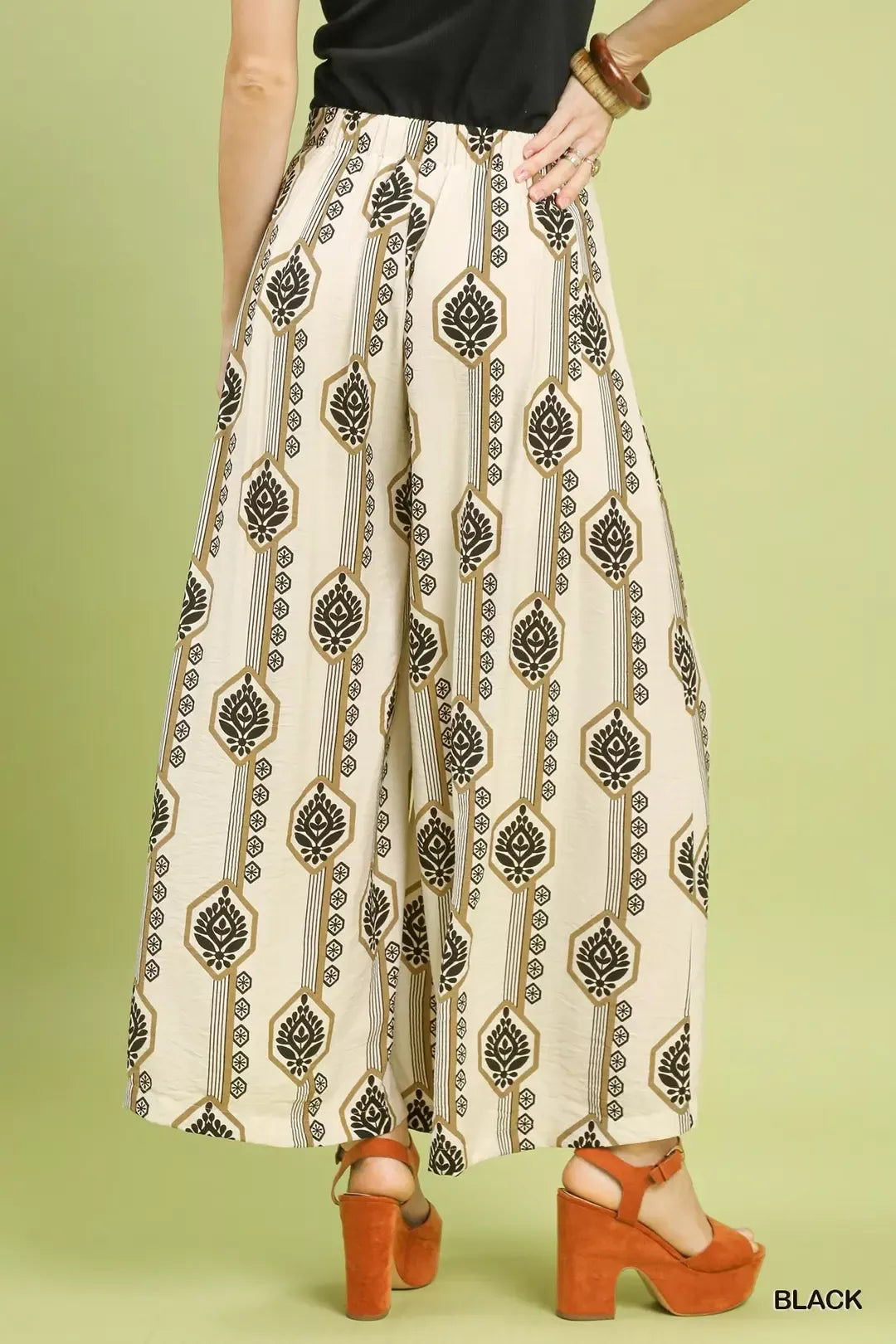 Printed wide-leg pants in cream with black boho pattern, flowing drape and gathered waist