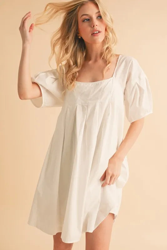 White square-neck babydoll dress with puff sleeves and relaxed gathered silhouette