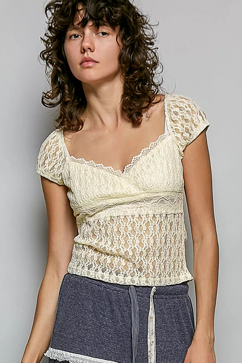 Natural lace sweetheart-neck short-sleeve top with fitted bodice and ruffle waist trim