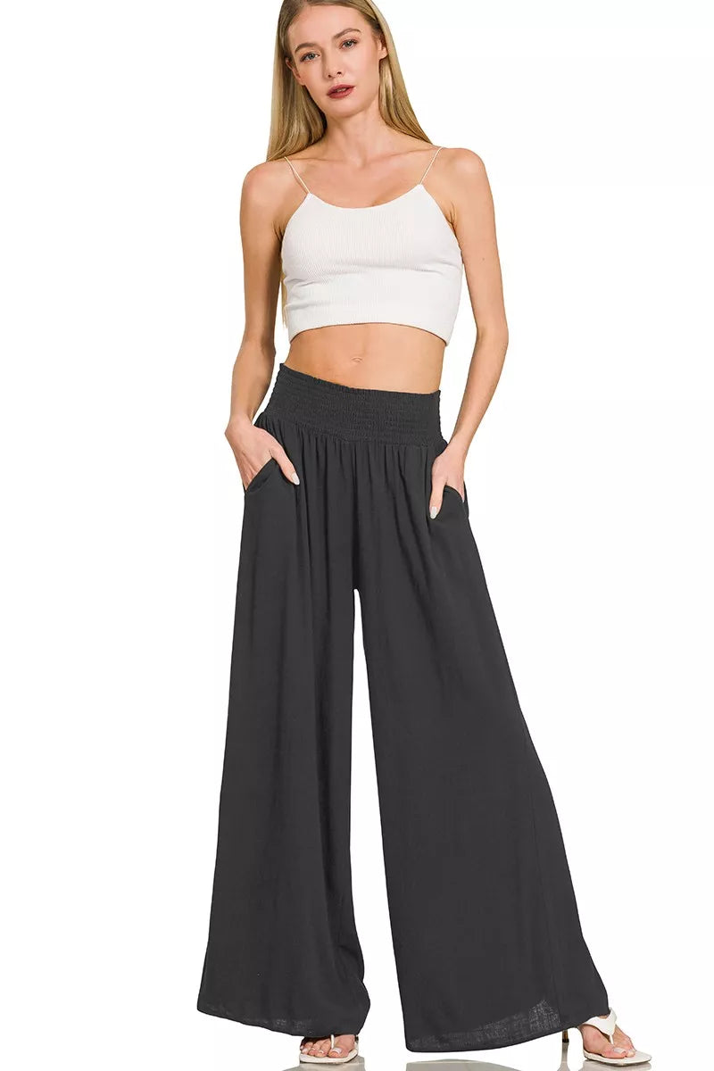 Black wide-leg lounge pants with smocked waistband and flowing wide silhouette