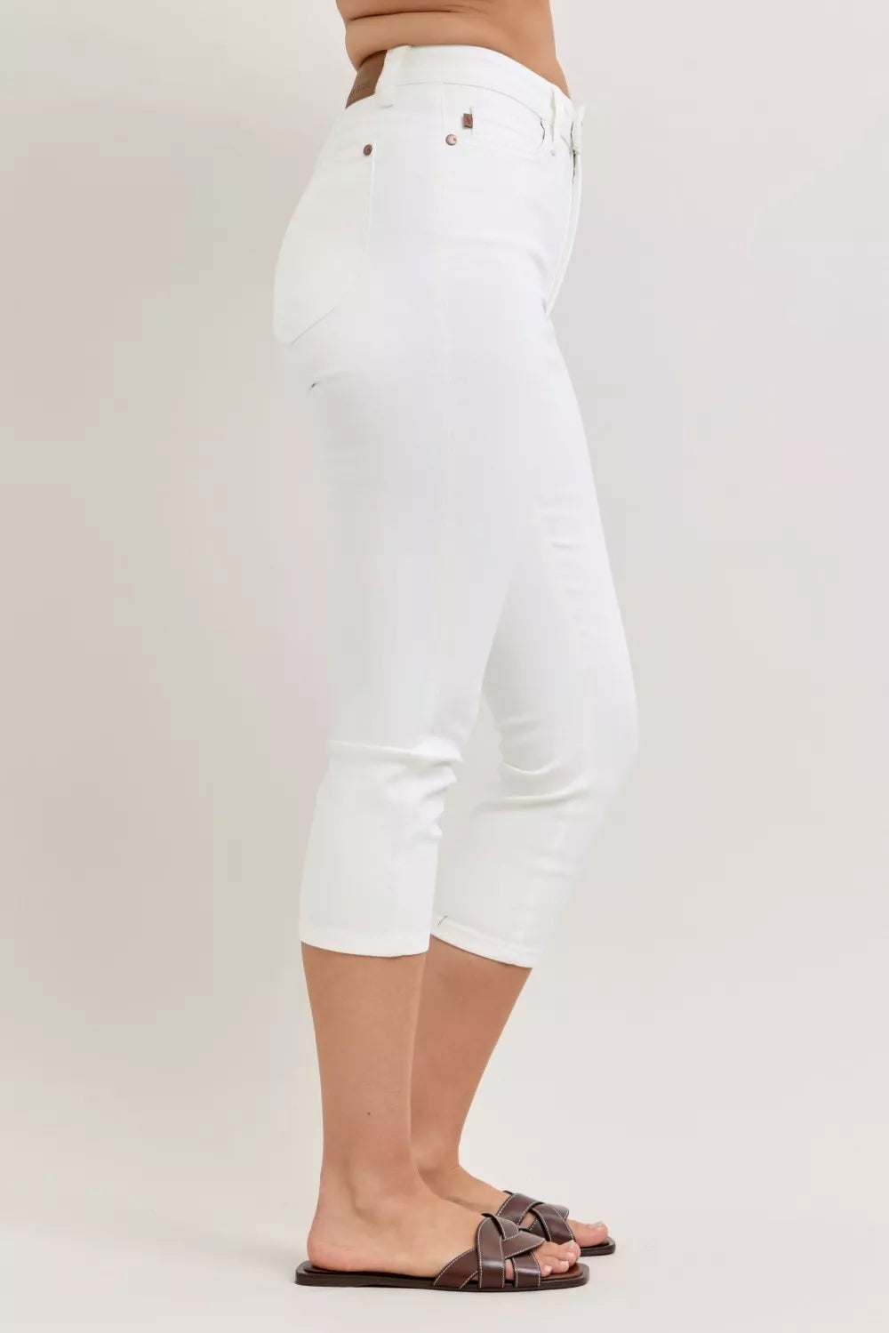 White high-waist capri jeans, side view, extended waistband and belt loops