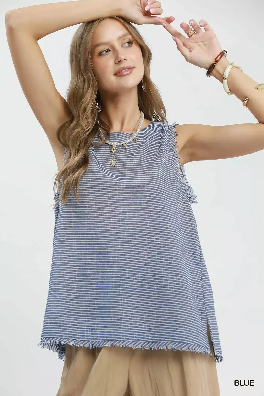 Blue striped sleeveless top with tassel fringe trim along the bottom hem
