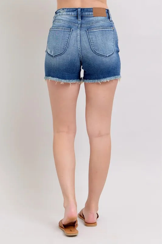 Blue denim shorts back, with shield-shaped pockets and raw frayed hemline