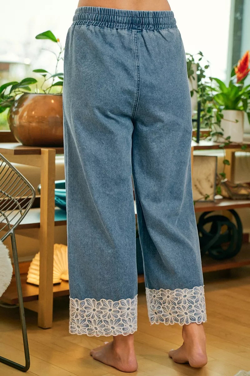 Blue washed denim wide-leg pants with drawstring waist and flower lace trim at cuffs