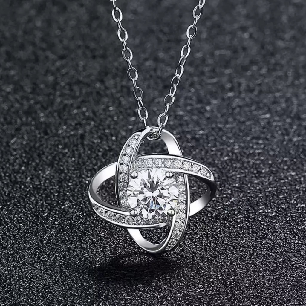 Silver pendant necklace with round center moissanite in curved setting with pavé accents