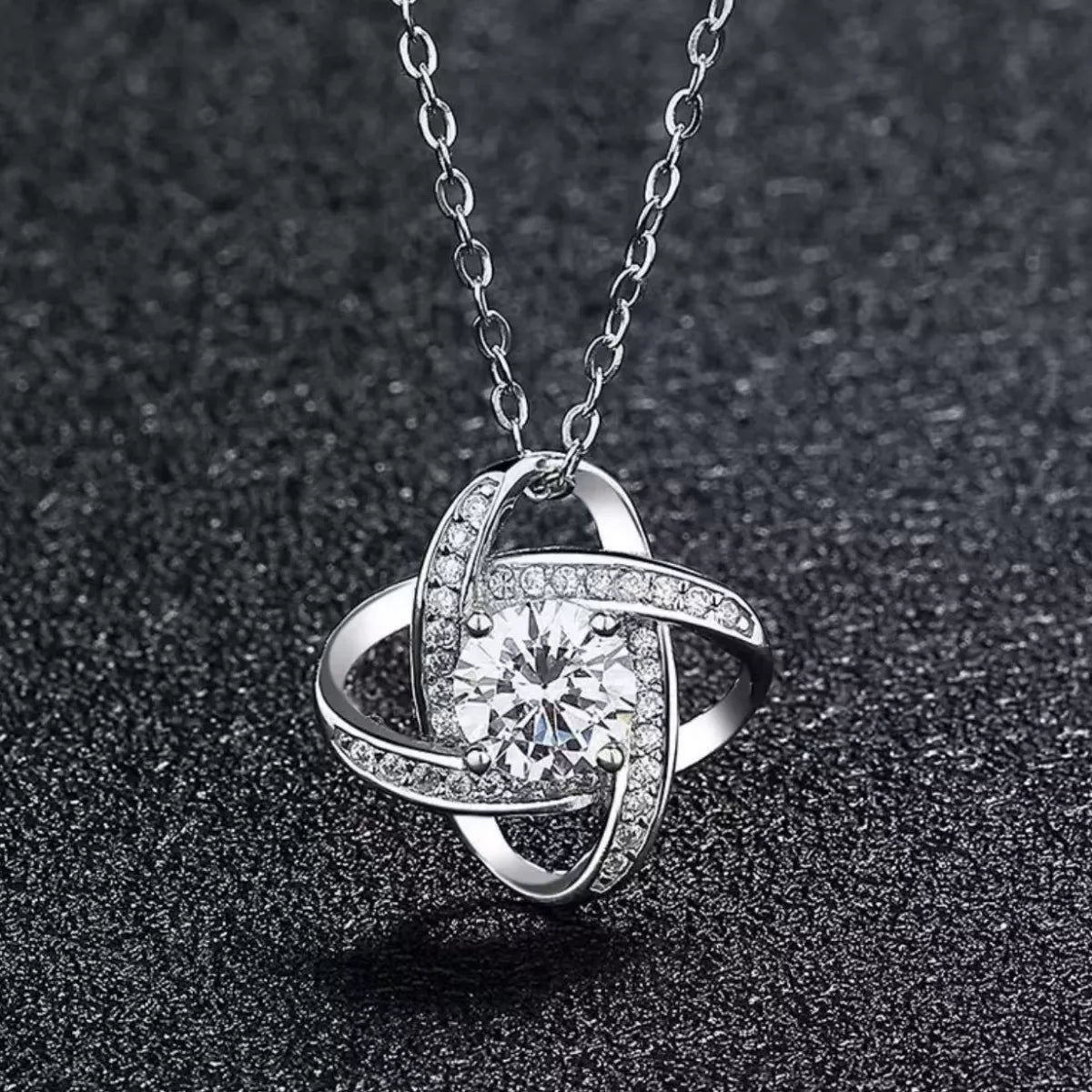 Silver pendant necklace with round center moissanite in curved setting with pavé accents