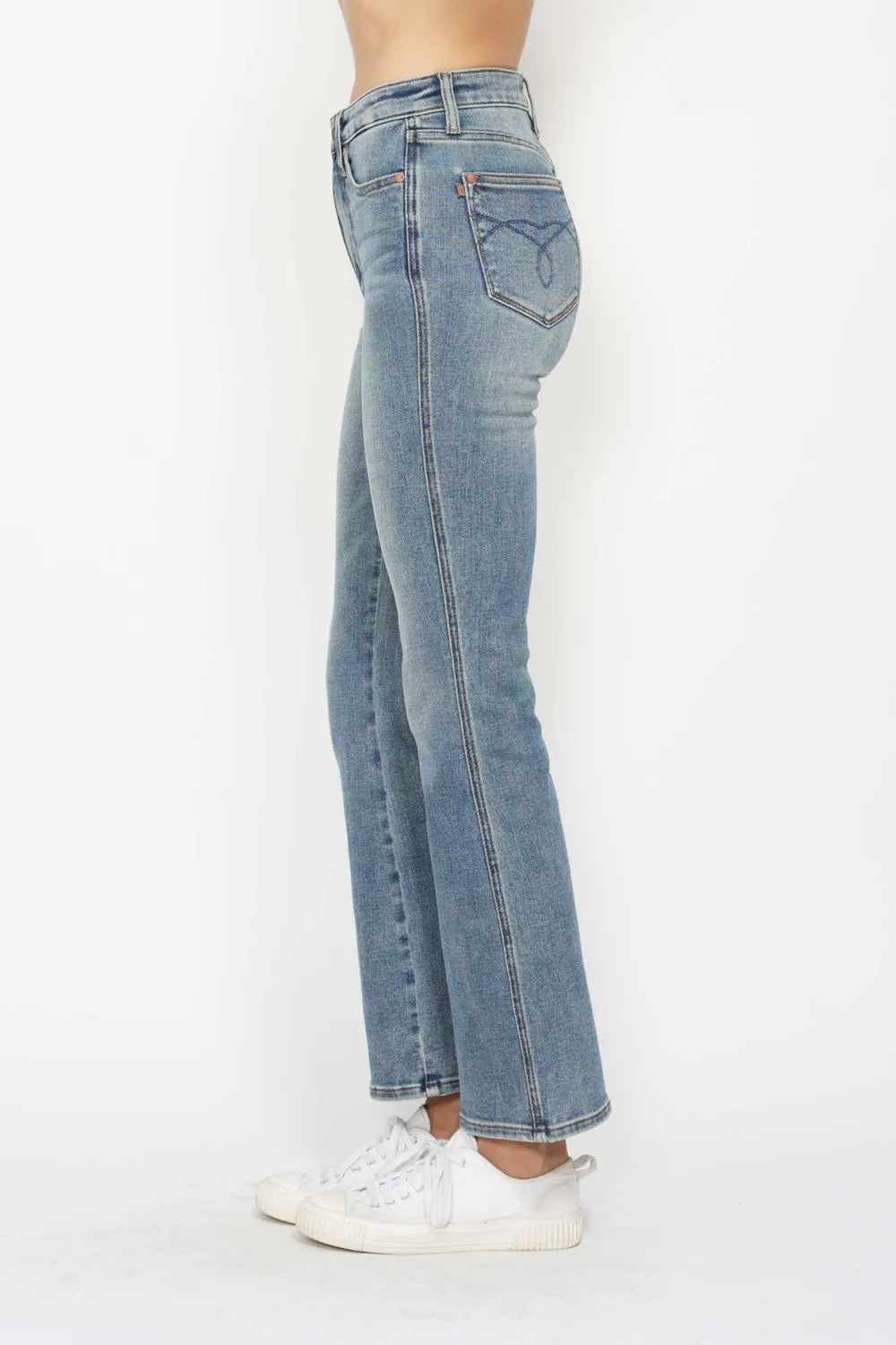 Light blue bootcut jeans, side view; embroidered back pockets and contrast stitching