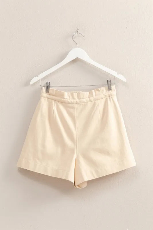 Oatmeal paperbag shorts on hanger, elastic waistband and front pleats