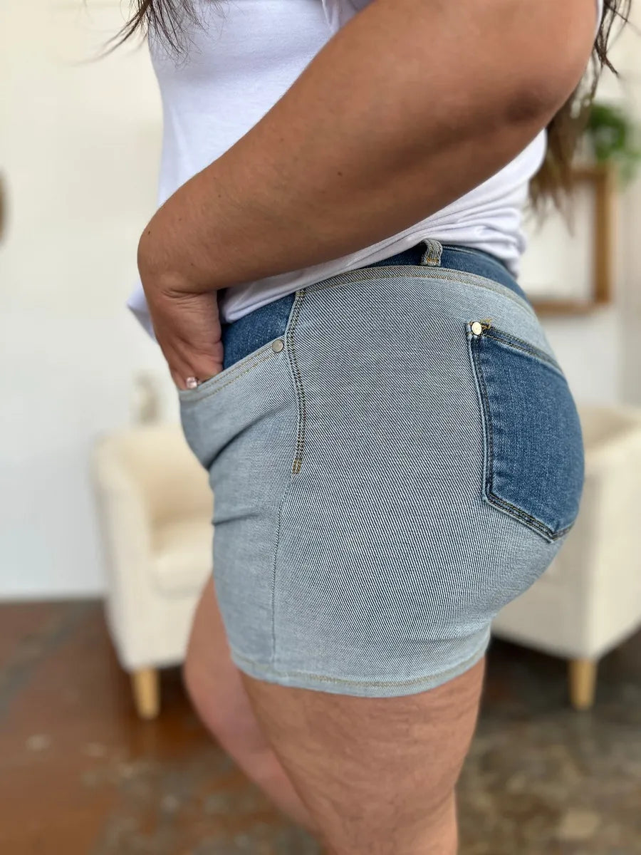 Jeansshorts Colorblock, Seitenansicht mit strukturierter Leinentasche und goldfarbenem Knopf