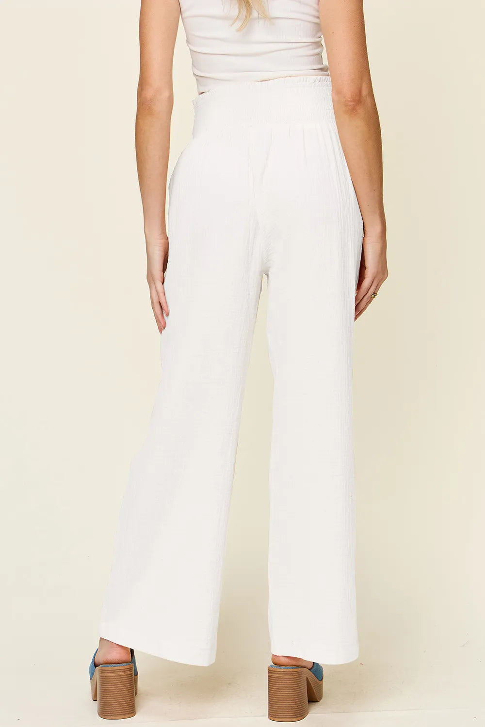 White textured wide-leg pants with smocked waist, straight relaxed legs