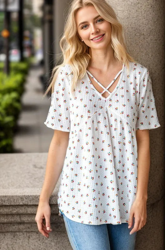 Floral babydoll top with crisscross V-neck and short sleeves, relaxed fit