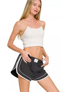 Black lined dolphin shorts with elastic waist and white contrast trim detail