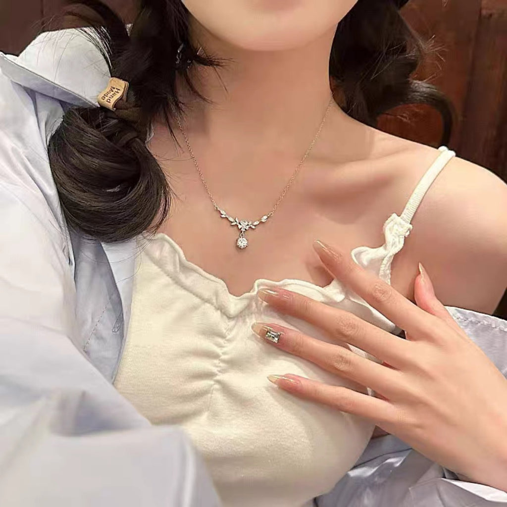 Leaf flower moissanite necklace worn, silver chain with small round pendant at center