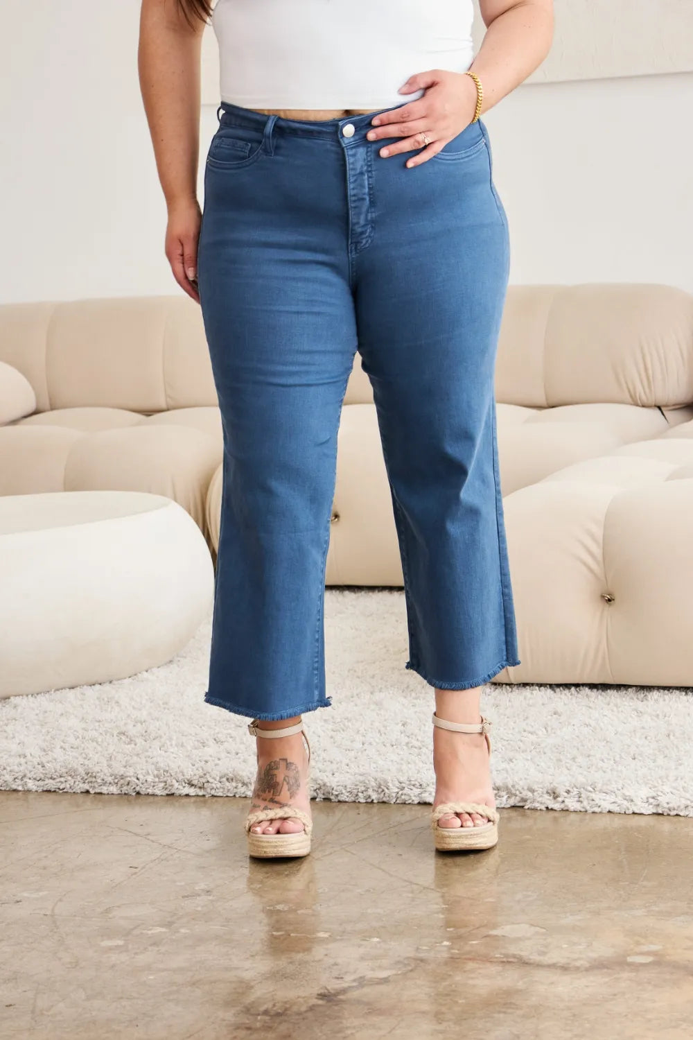 Close-up: high-rise blue denim jeans with button fly and raw hem