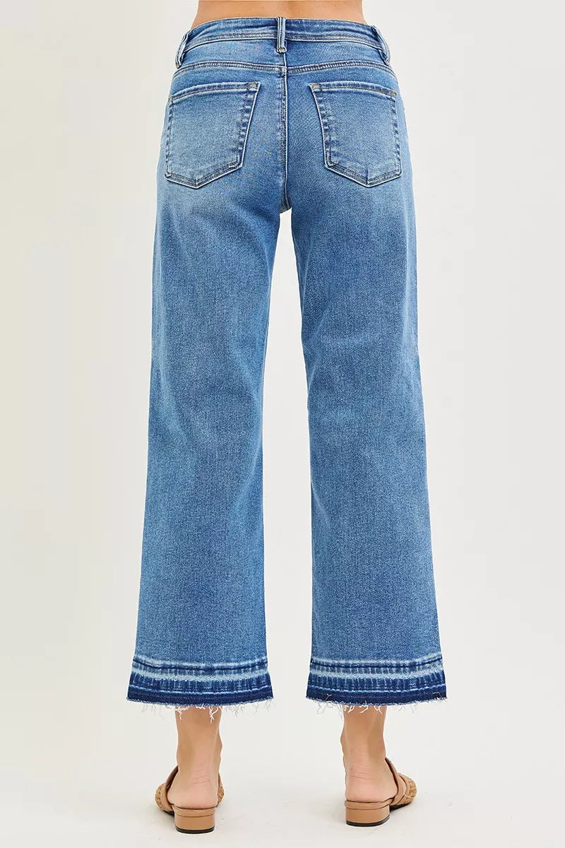 Back view of medium-wash cropped boyfriend jeans with two patch pockets and frayed hem