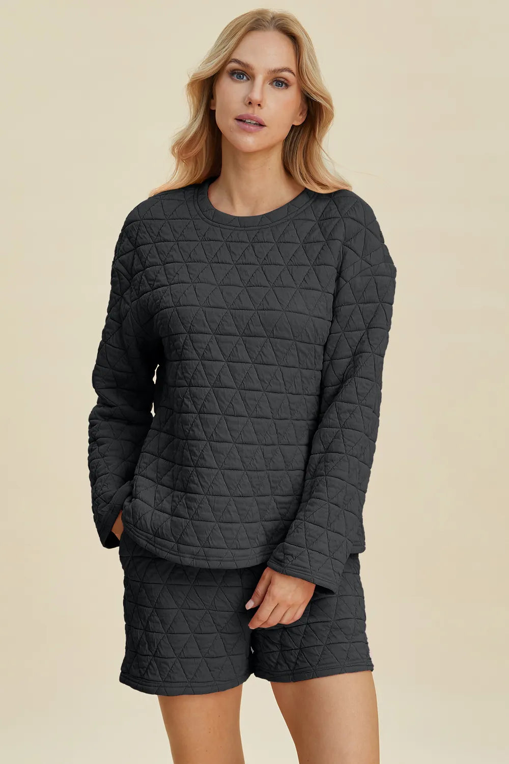 Black quilted long-sleeve top and matching shorts set, round neck, geometric triangle pattern.