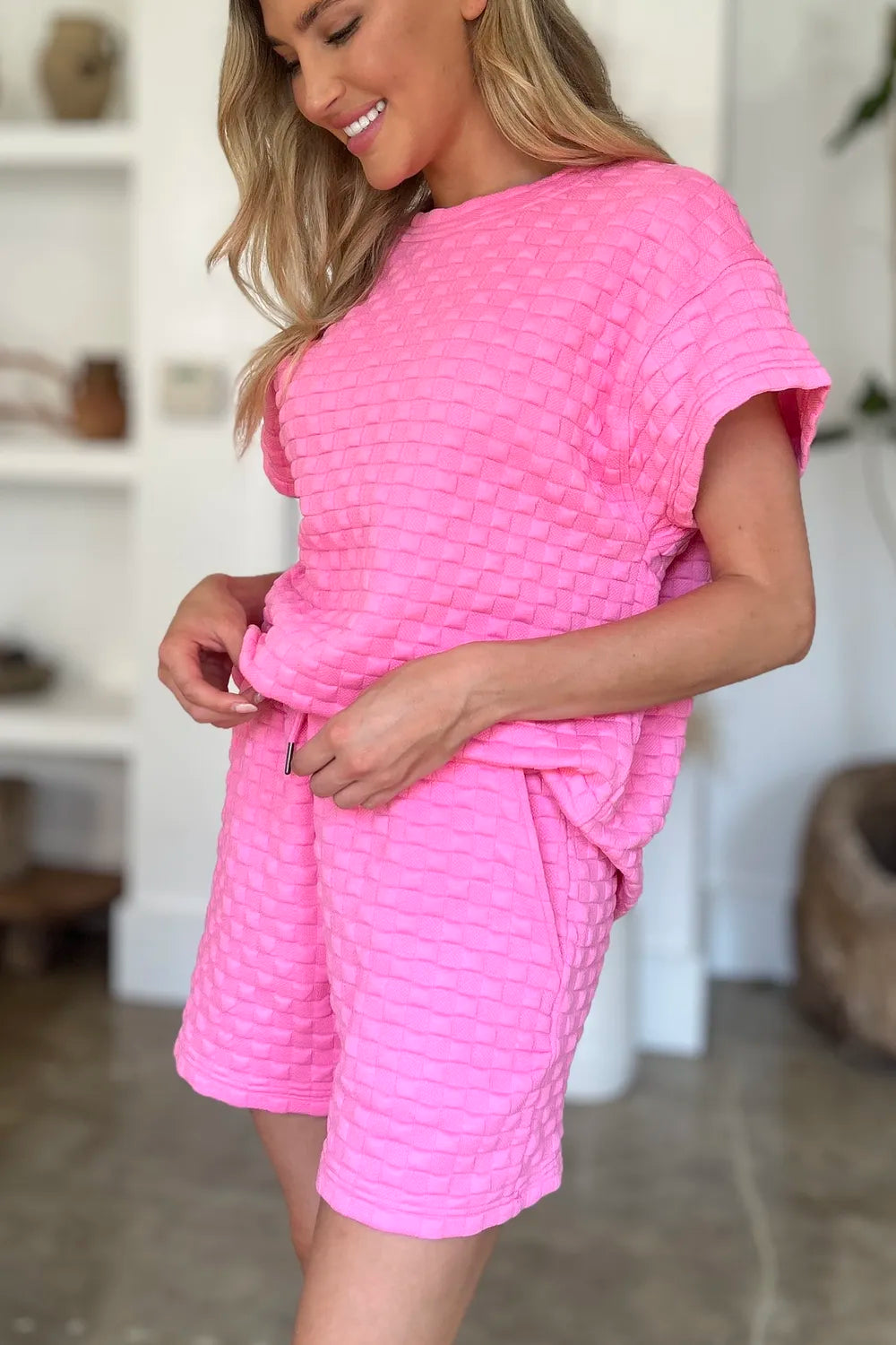 Pink textured T-shirt and shorts set, side view of elastic waist and drawstring tie