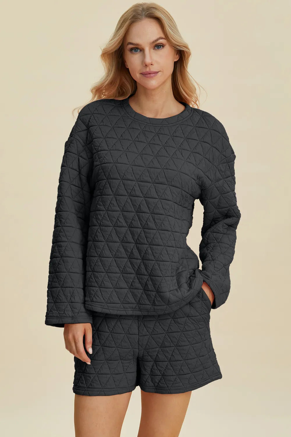 Black quilted long-sleeve top and matching shorts set, round neck, geometric texture.