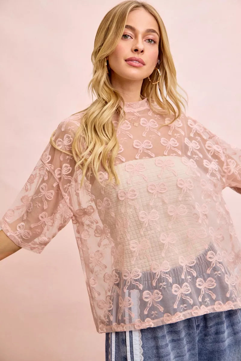 Dusty rose semi-sheer mesh top with allover bow pattern, boxy short sleeves