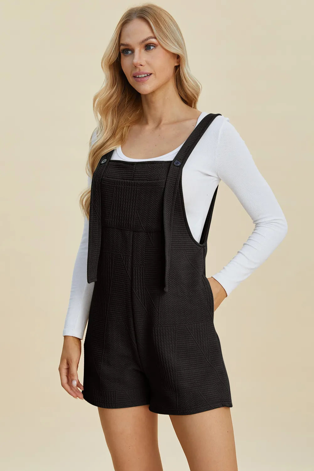 Double Take nero: romper senza maniche con spalline e tasche frontali, vista 3/4.