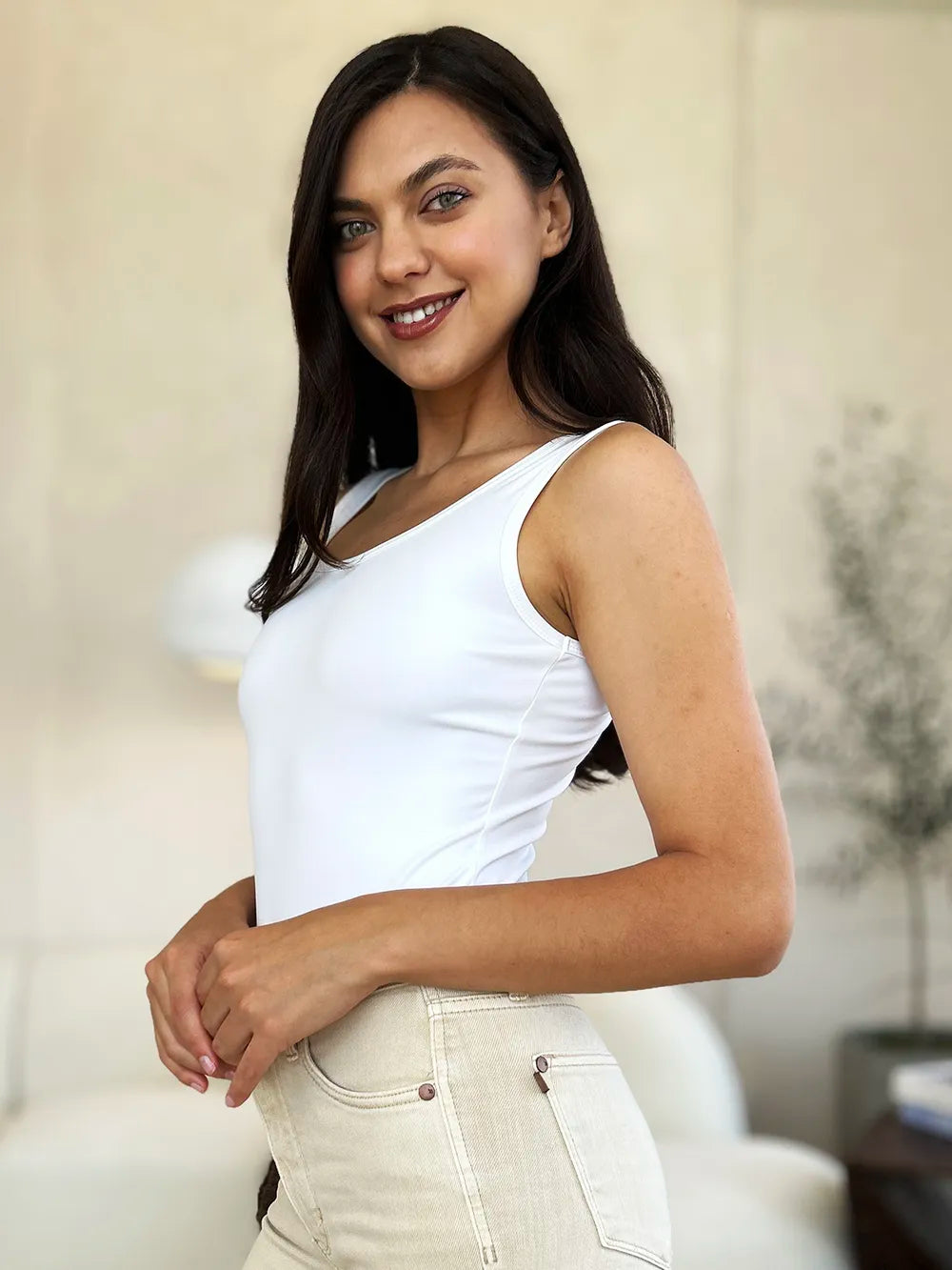 White sleeveless bodysuit with crew neckline, side view and high-cut leg openings