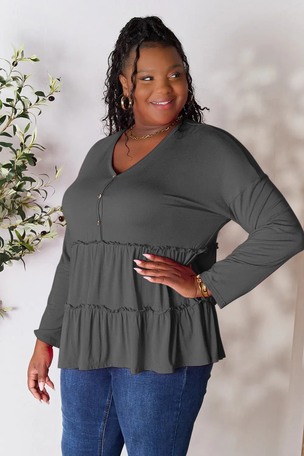 Dark gray V-neck half-button blouse with tiered ruffle hem and long sleeves