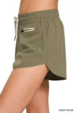 Dusty olive shorts with drawstring ties and zip coin pocket detail on the side