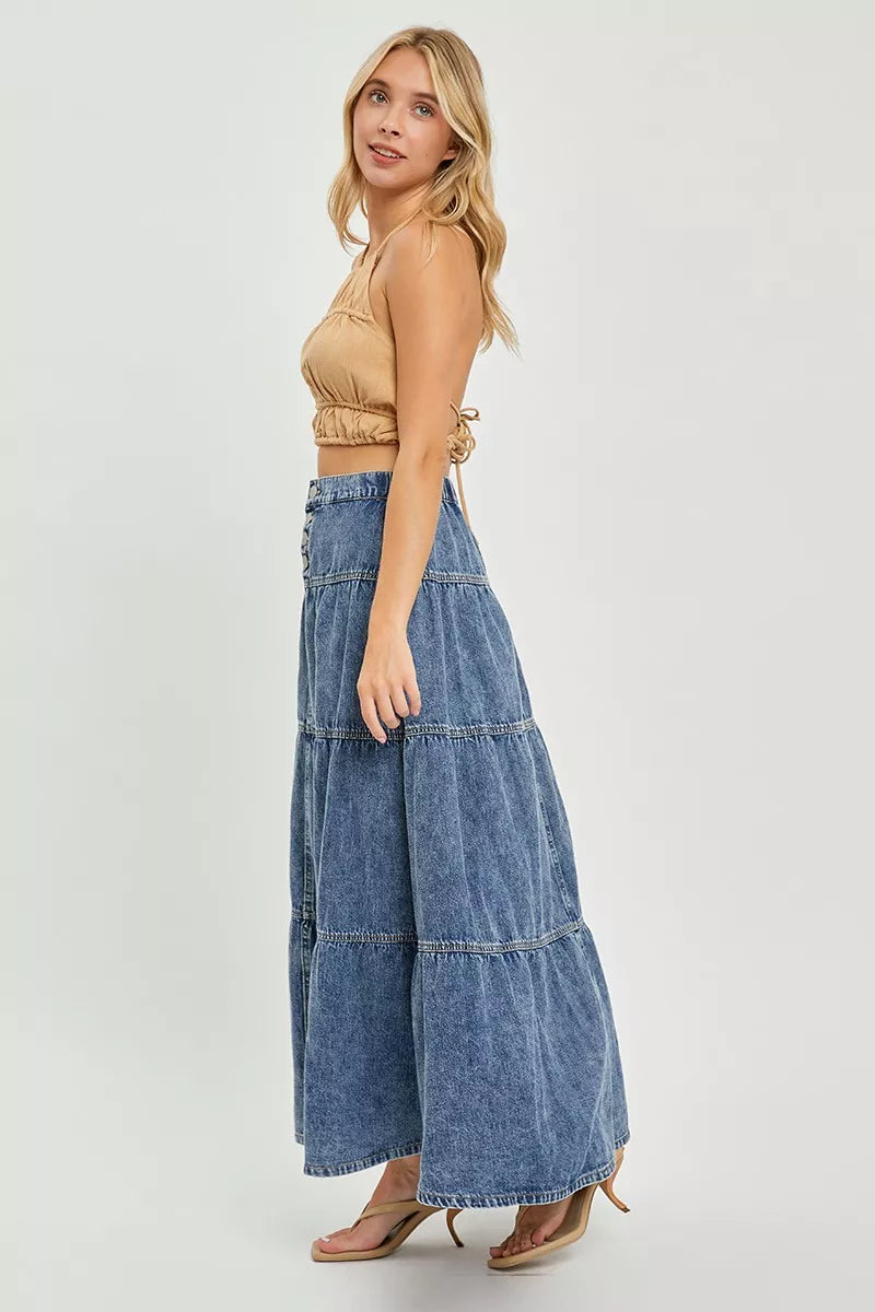 Side view of high-rise denim long skirt with tiered ruffle panels and button closure, medium wash