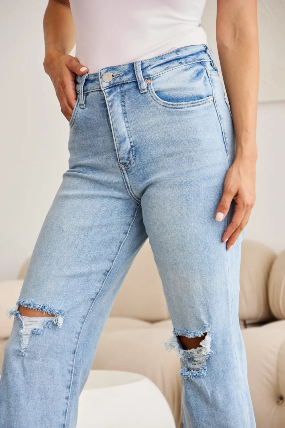 Light wash high-waist denim jeans with button fly and frayed raw hem