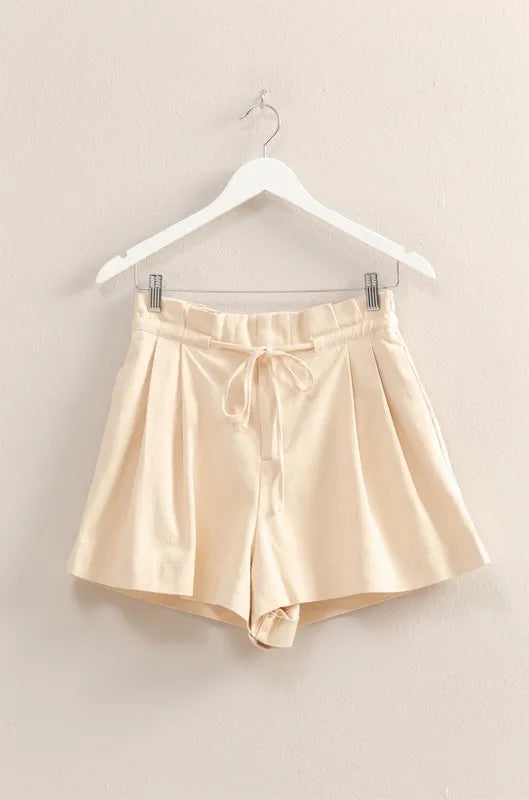 Oatmeal paperbag shorts on hanger, drawstring bow and pleated waistband