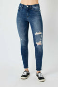 High-waist skinny jeans in dark blue denim with distressed knee rips and frayed cuffs