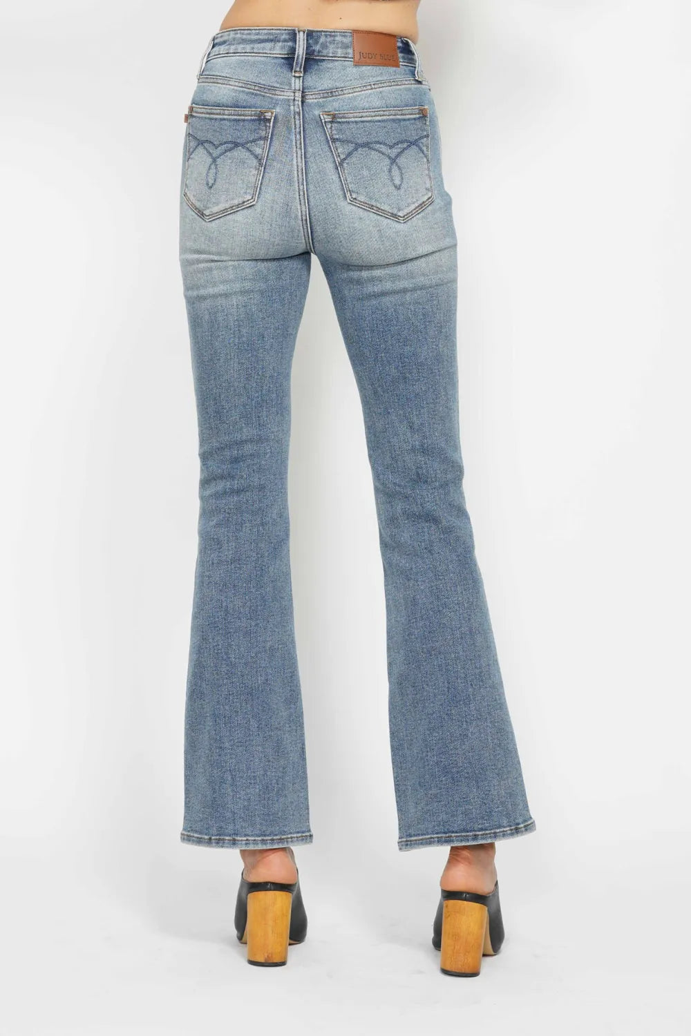 Light blue bootcut jeans, back close-up; embroidered pockets with belt loops