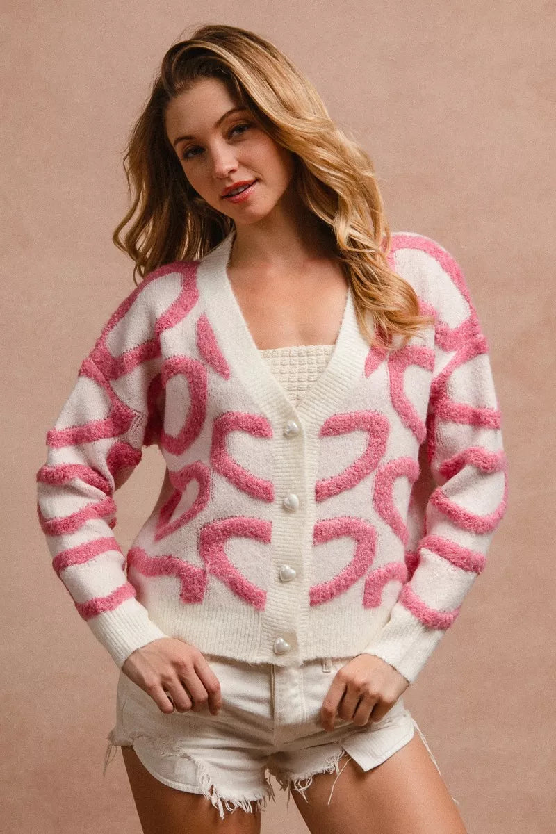 Cardigan con botones al frente, blanco con patrón rosa de corazones y cuello V