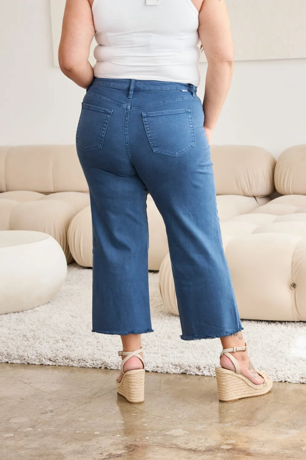 Back view: blue high-waist jeans with straight fit and raw hem