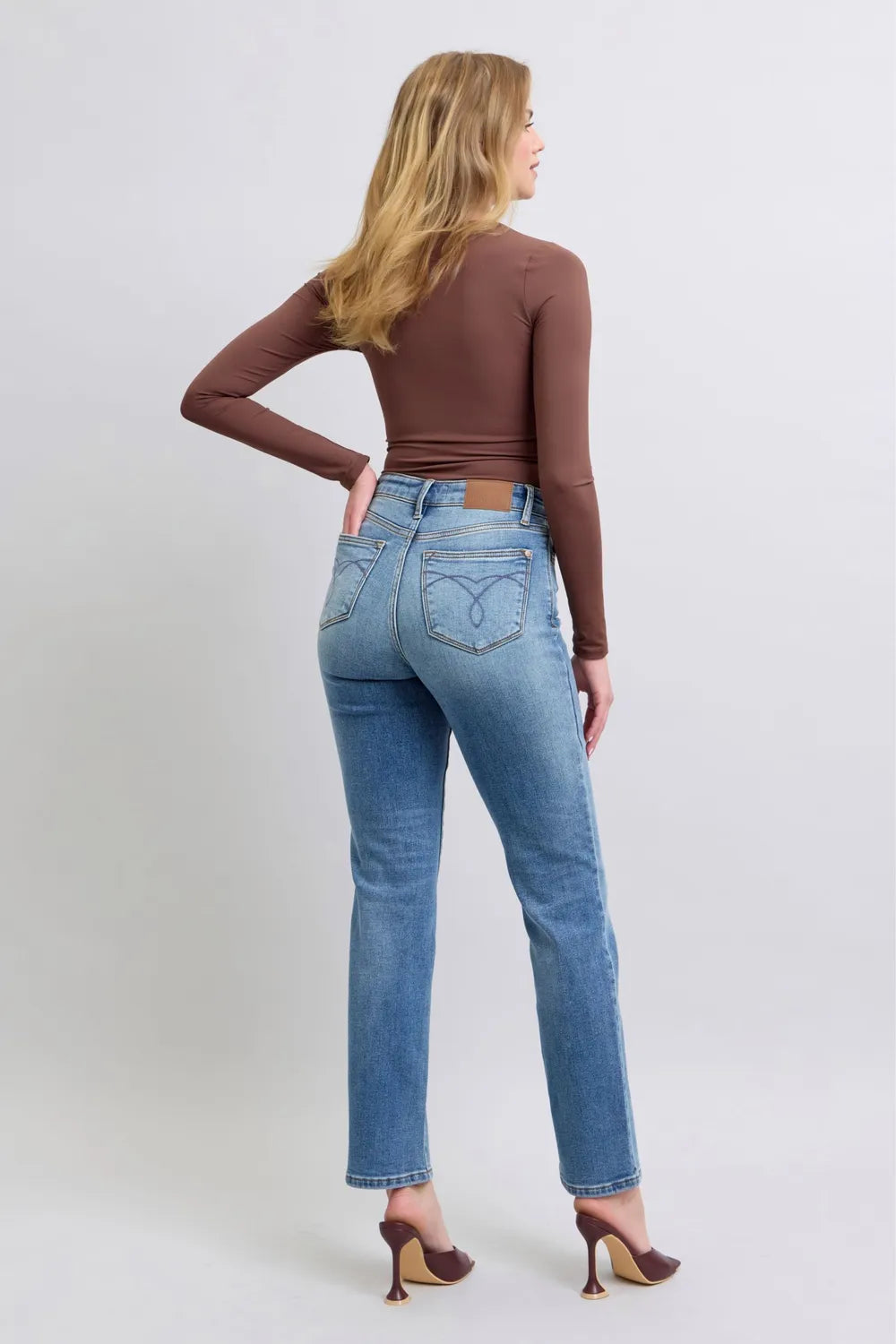 Medium-wash vintage straight jeans from back view with belt loops and back pockets