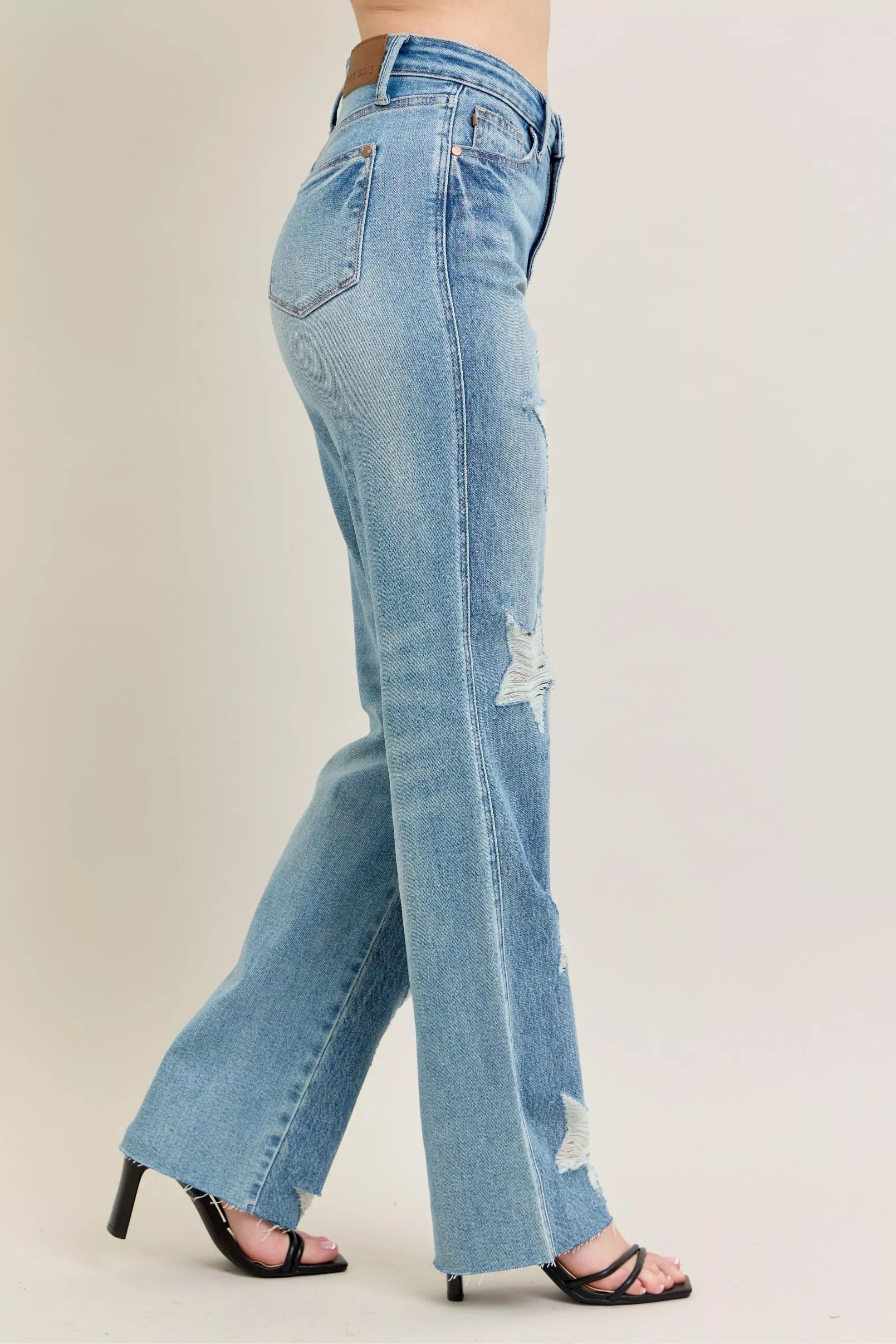 Light-wash straight jeans with star-shaped rips along the legs