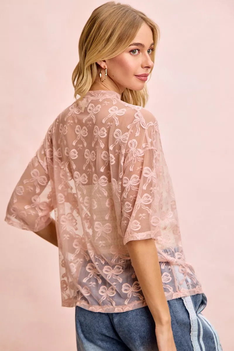 Dusty rose mesh top with bow pattern, back view, loose boxy short sleeves