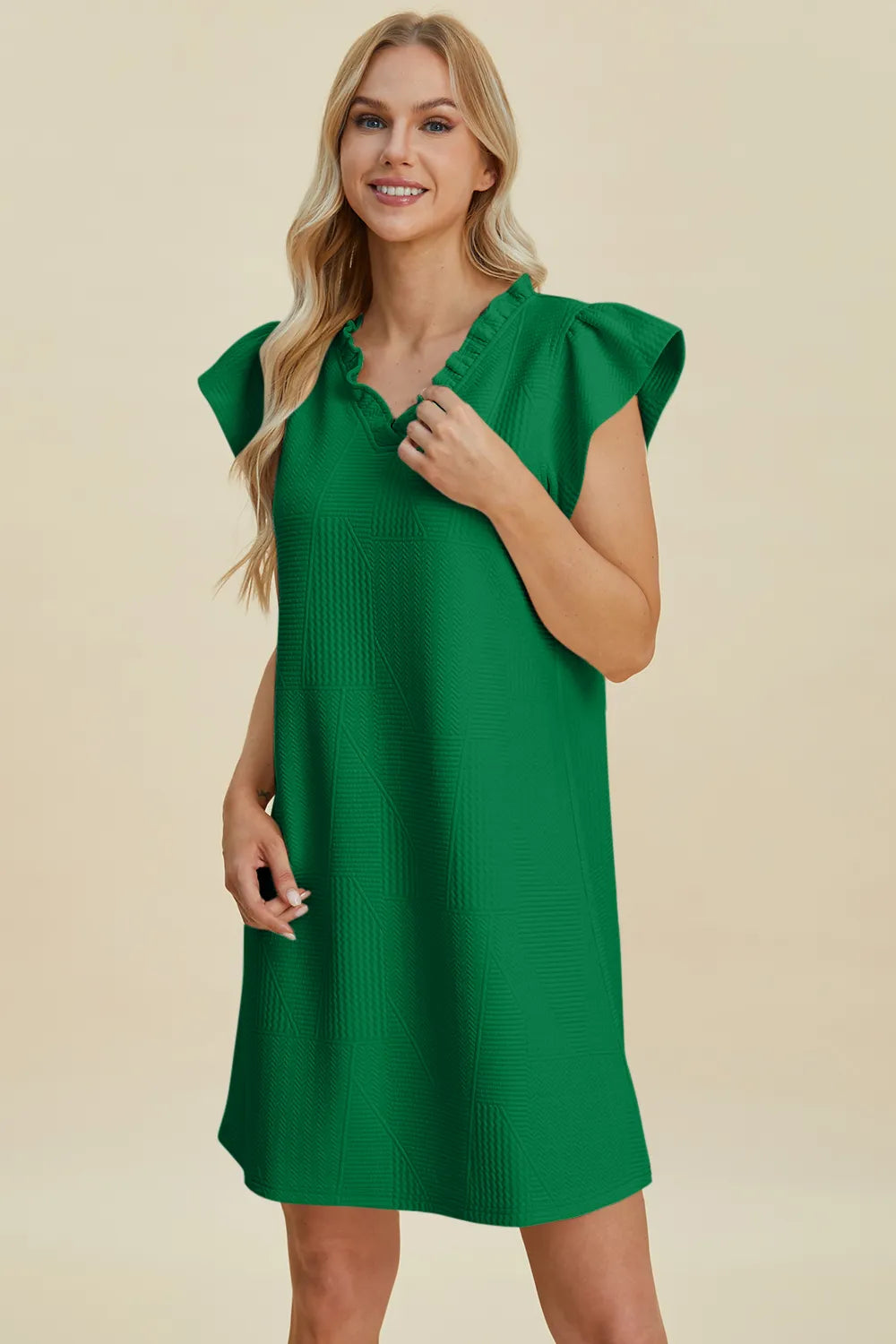 Ruffled V-neck cap sleeve dress in dark green with short sleeves and textured detail.