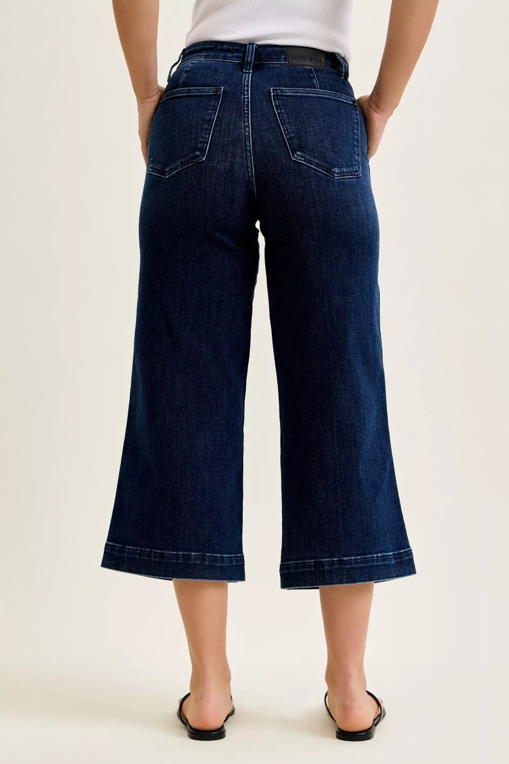 Back view of dark wash DK high waist wide-leg ankle jeans with wide cropped leg