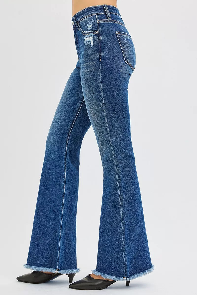High-rise flare jeans in dark wash denim with ripped knee detail and flared leg.